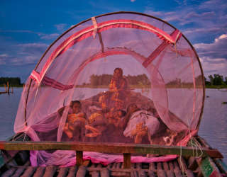 네 식구가 배에 모기장을 설치해 잠을 청합니다. Photo: WFP/Sayed Asif Mahmud